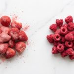 Liofilizowane truskawki i maliny porównanie — dwa owoce na białym marmurze